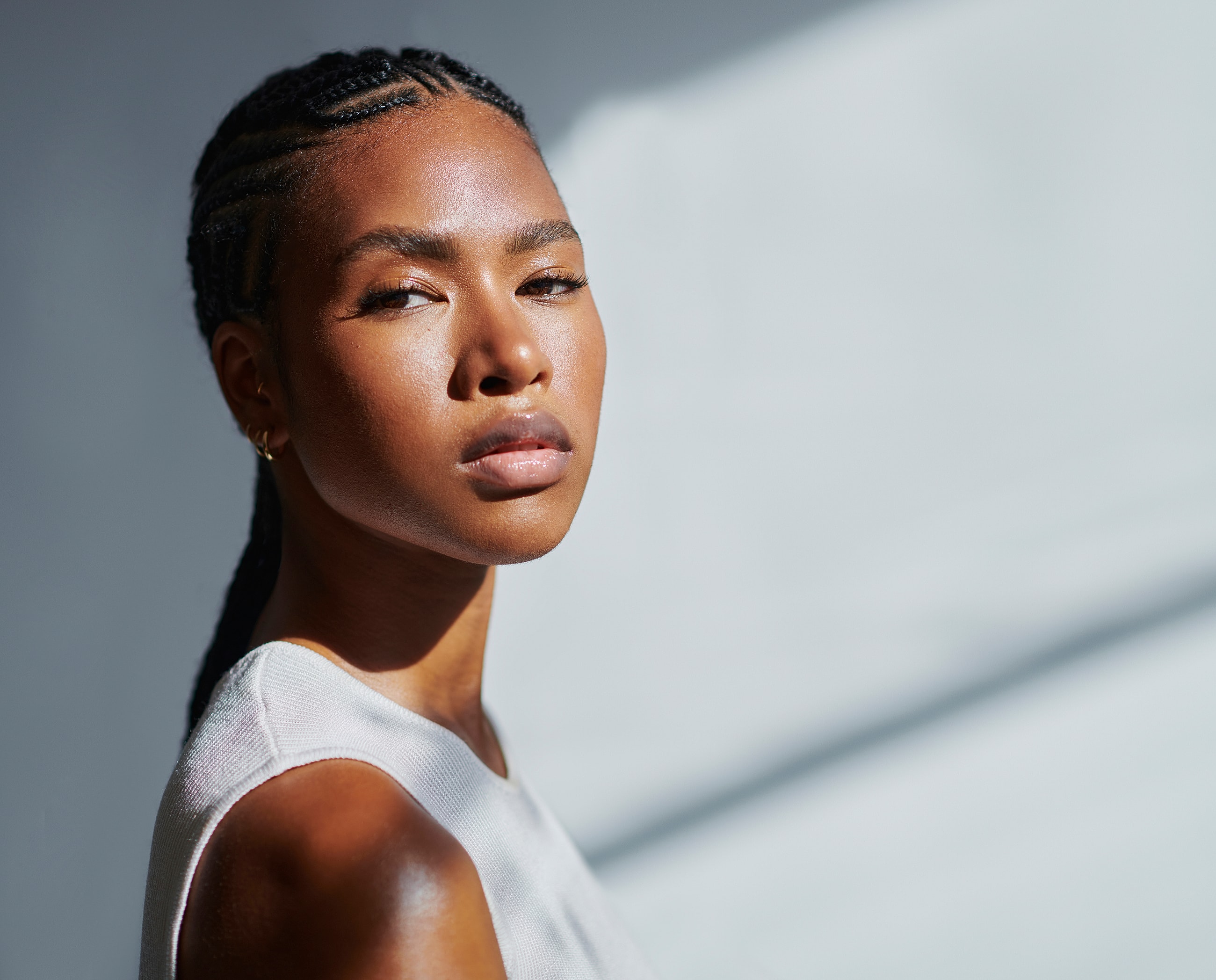 Person with braided hair in soft lighting.
